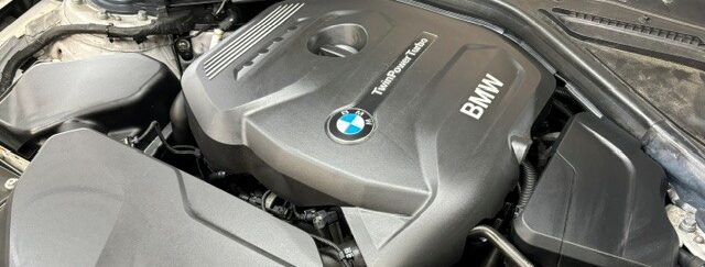 Ein BMW-Motor mit dunkler Abdeckung und sichtbarem Turbolabel.